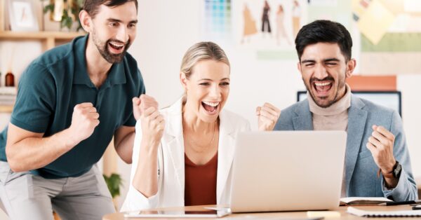Office, laptop and team with excited fist about successful news for career deal or reward for compa