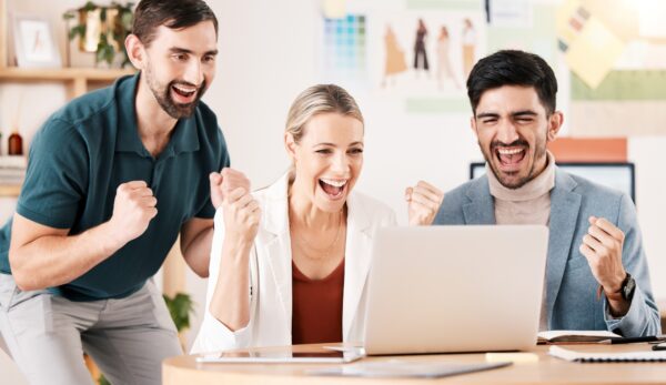 Office, laptop and team with excited fist about successful news for career deal or reward for compa