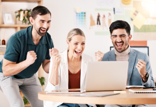 Office, laptop and team with excited fist about successful news for career deal or reward for compa